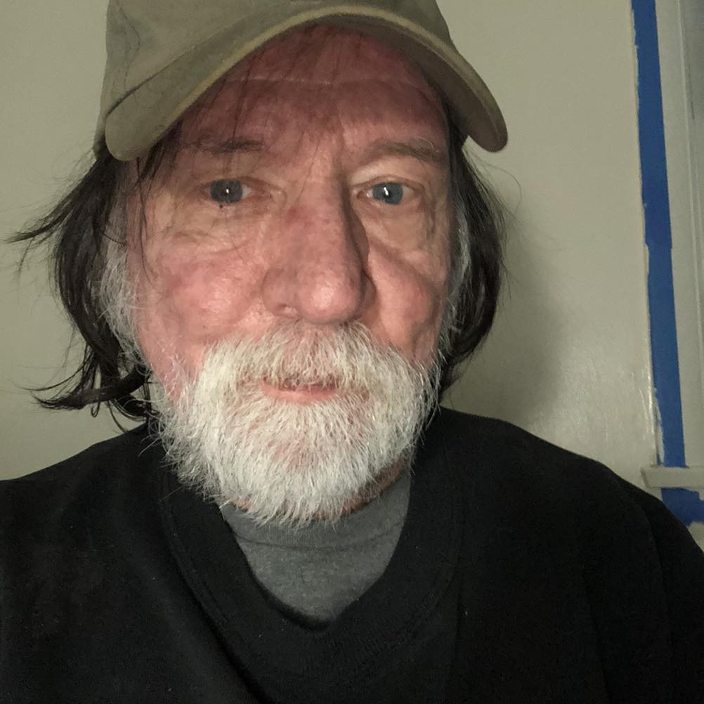 A close-up selfie of a senior man with a white beard and a khaki baseball cap, providing a genuine review after a spray foam removal project in Alfreton.
