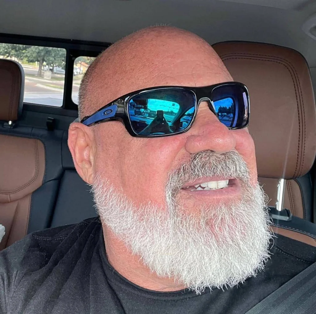 Professional headshot of a smiling man in a bright orange shirt, sharing his positive experience after a loft insulation extraction project in Luton, Bedfordshire.