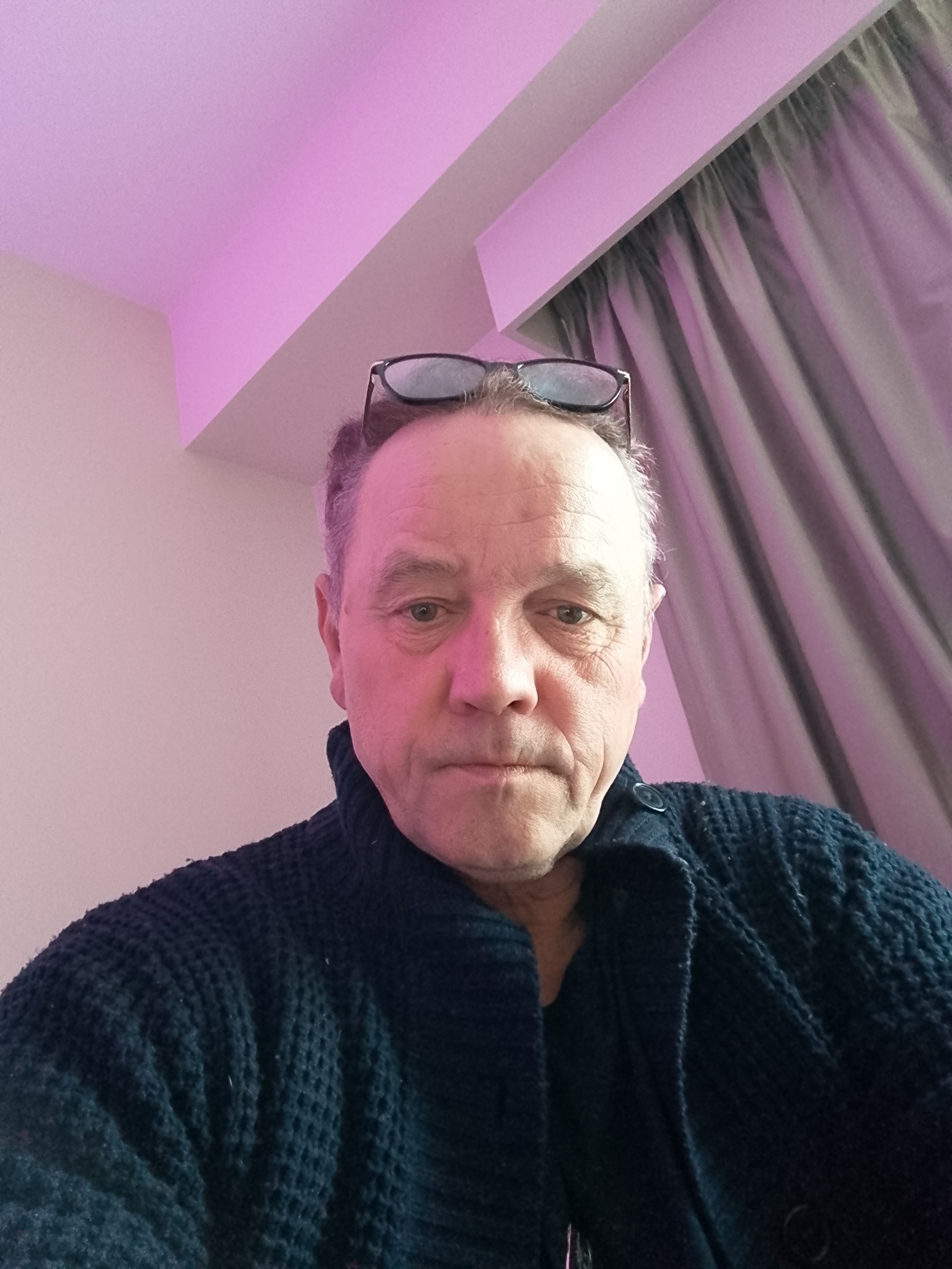 Professional headshot of a smiling man with brown hair and glasses, wearing a bright orange button-down shirt, used as a customer testimonial for insulation services in Luton.
