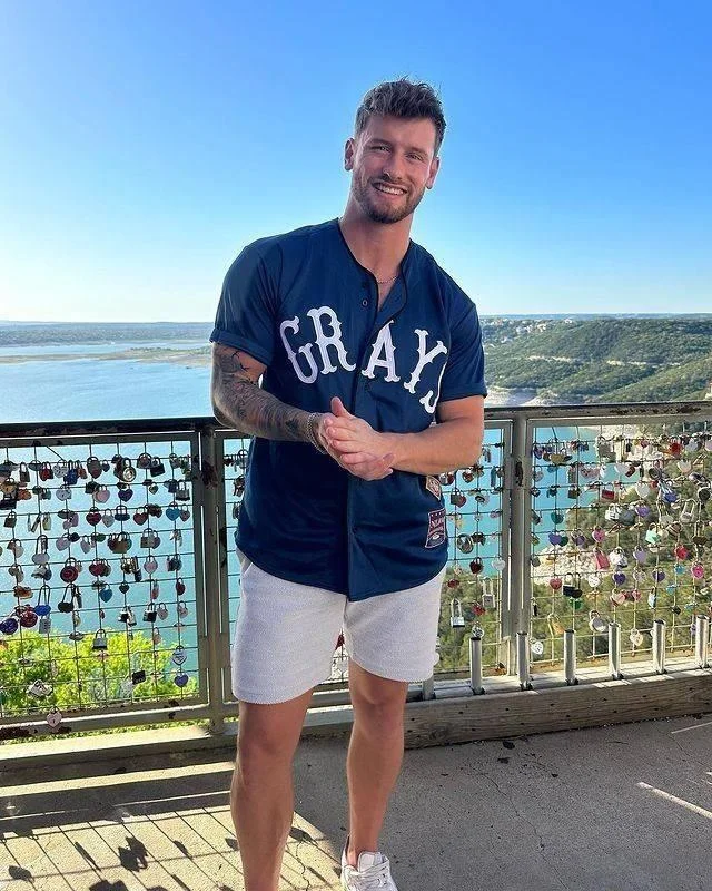 A portrait of a middle-aged man with grey hair and glasses, wearing a brown jacket over a white t-shirt. He is standing in a timber-framed shed, used as a customer testimonial for loft timber cleaning in Newcastle.