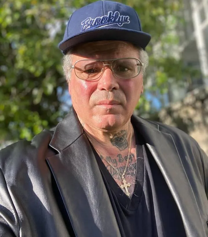 A smiling middle-aged man with short blonde hair, wearing a dark navy suit and a light green patterned tie. He represents a professional homeowner in Oakham, Rutland, who successfully resolved mortgage survey issues.