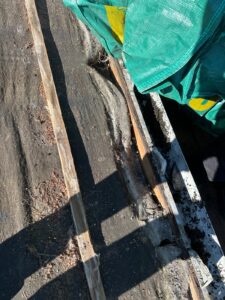 Old roof battens and green roofing felt exposed during roof stripping and renovation work in Bristol