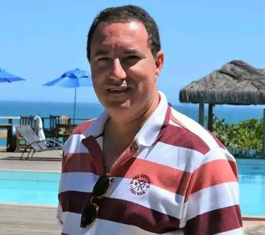 A professional man in a blue suit and tie with arms crossed. Represents a homeowner in Sheffield who successfully resolved mortgage issues through spray foam removal.