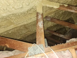 Spray foam insulation applied to roof rafters with fiberglass insulation between joists in Devon loft space
