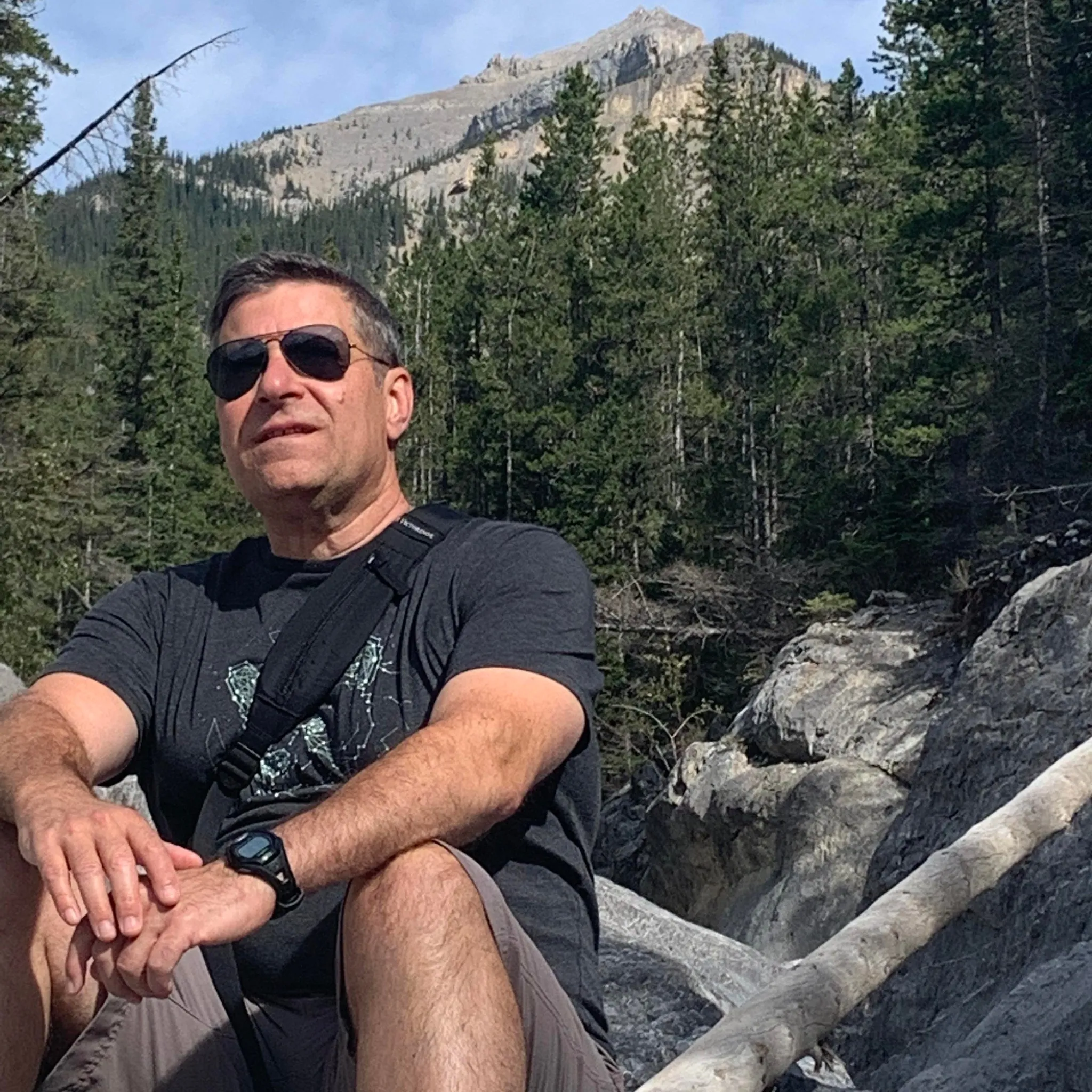 A professional man with glasses and a black puffer vest standing in front of a modern residential building in St Albans. He represents a local homeowner who successfully navigated a mortgage survey after spray foam removal.