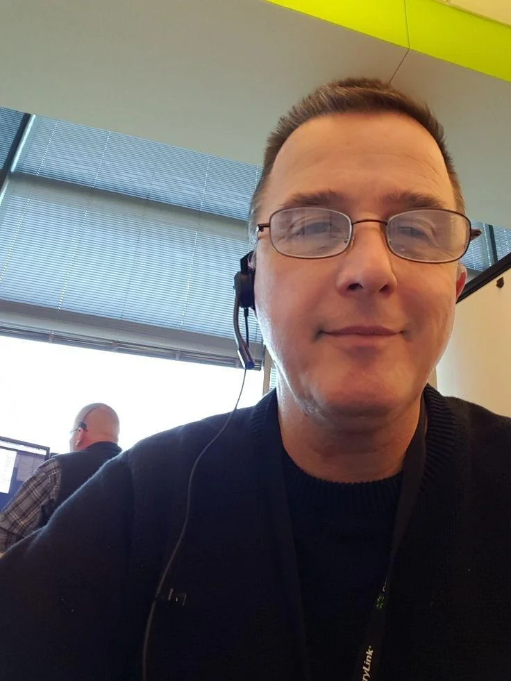 A smiling man with a mustache and glasses, wearing a light blue button-down shirt. The photo is framed by a ring light, used for a property service testimonial in the Sunderland and Tyne and Wear area.
