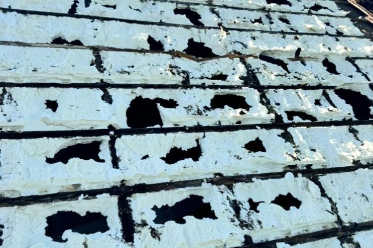 Expert spray foam removal and roof restoration in Bedfordshire, removing old insulation and replacing damaged roof tiles with scaffolding