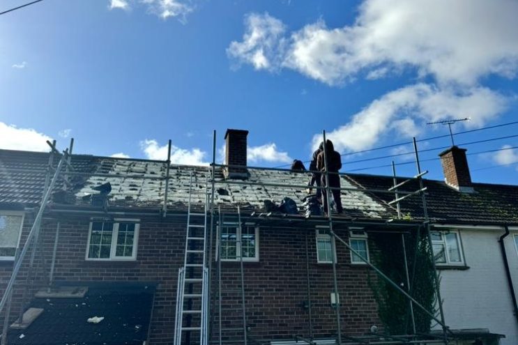 Professional spray foam insulation removal and roof repair in Bristol, contractors working on scaffolding to remove old foam and restore roof structure
