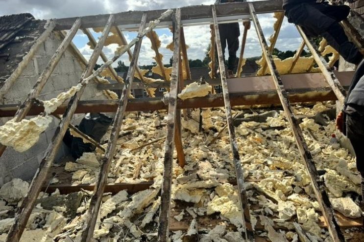 Spray foam insulation removal in Cornwall showing roof rafters and foam extraction, professional roofing contractors removing old insulation with scaffolding