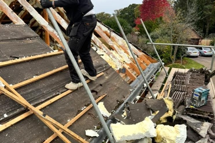 Roofer removing spray foam insulation from timber rafters in Derbyshire, professional extraction and roof restoration service