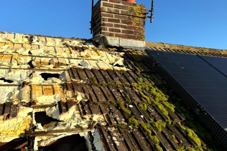 Spray foam insulation removal in Lincolnshire showing damaged roof tiles with moss growth and exposed insulation, professional roof restoration service