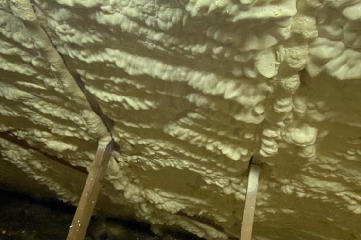 Spray foam insulation removal in Somerset, showing thick foam layer on roof rafters and loft structure requiring professional extraction service