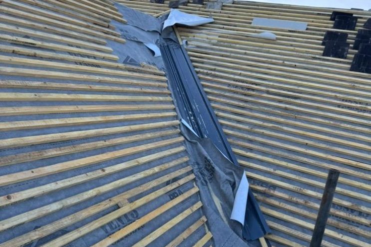 Spray foam insulation removal in Suffolk showing exposed roof battens and roofing felt during roof restoration, professional timber structure preparation