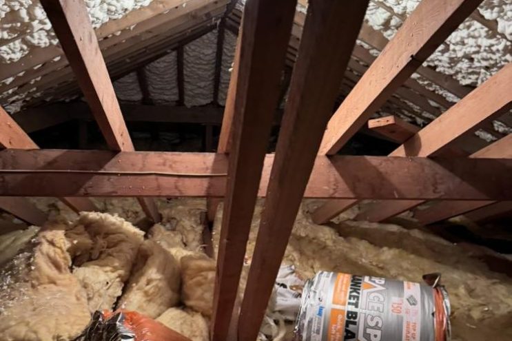 Spray foam insulation removal in West Yorkshire showing timber roof rafters with foam insulation and insulation materials, professional attic extraction service